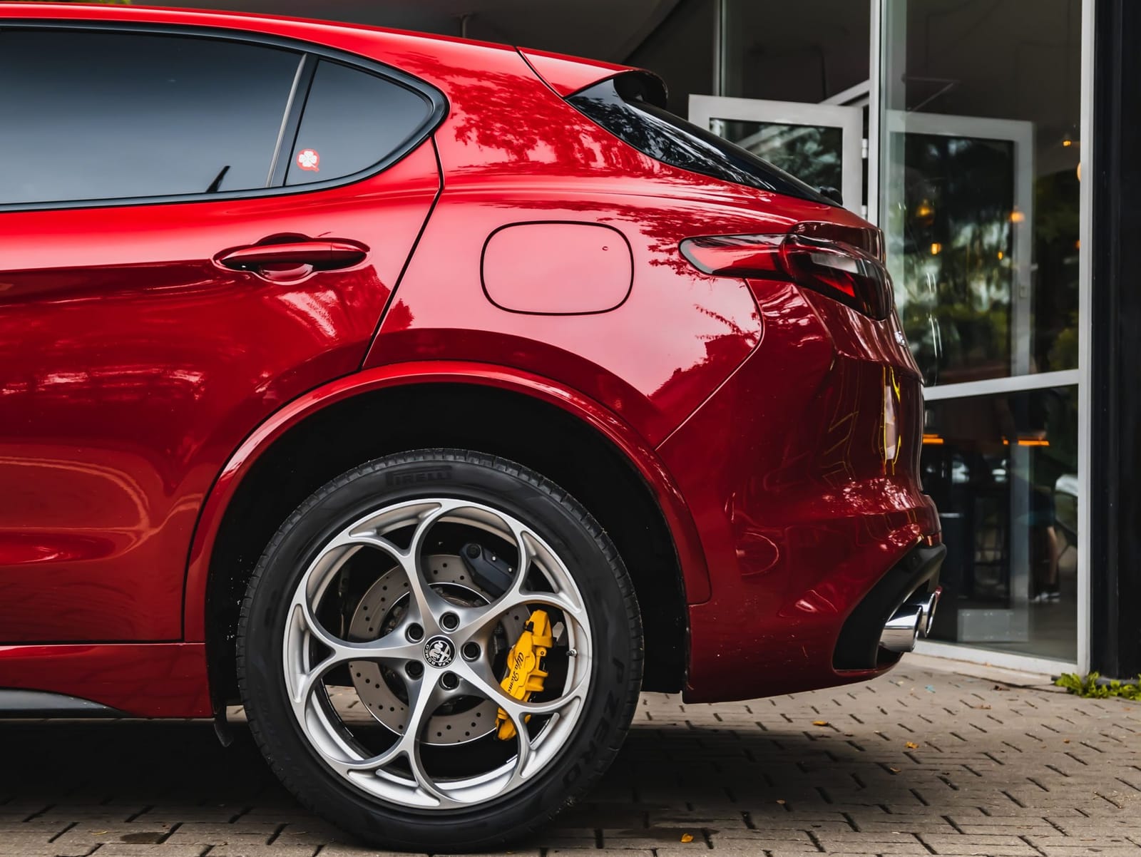 Red Italian SUV with performance brakes parked outside a showroom