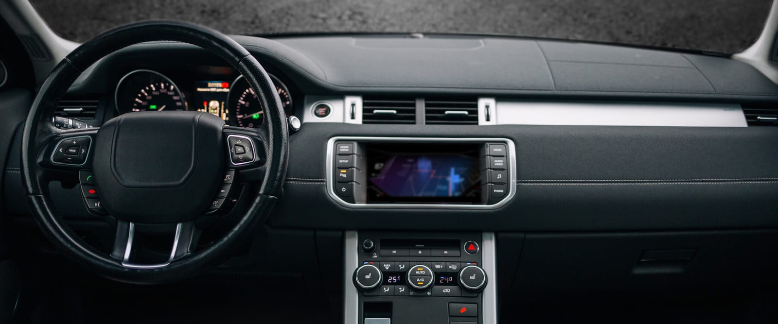 Clean, uncluttered SUV dashboard with a leather steering wheel, instrument cluster and centre touchscreen